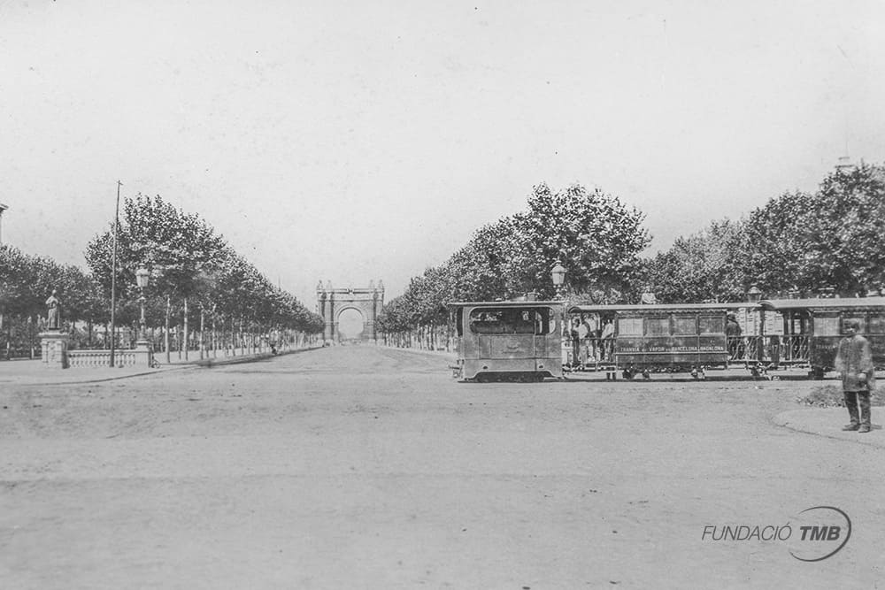 Steam tram running on the Barcelona - Badalona route at the Arc de Triomf. Steam trams ran in Barcelona between 1877 and 1902. They arrived to replace animal-powered trams and were later replaced by electric trams. This is the oldest image from the PH photographic archive.