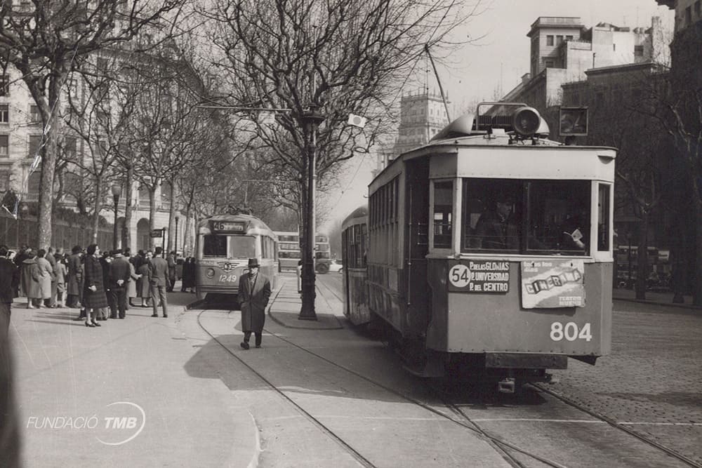 Tramvies de les línies 54 i 46 a la Gran Via de les Corts catalanes amb la cantonada carrer del Balmes el 1951.