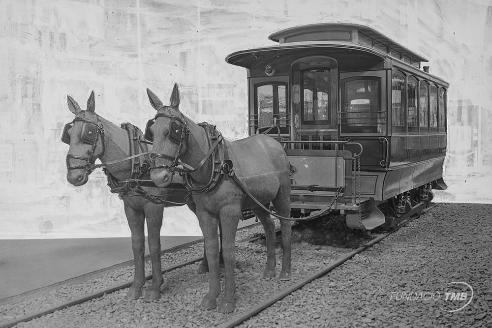 Image of an animal-powered tram, like the ones that were used when Barcelona's first tram route was launched on 27 June 1872.  The trams were pulled by mules or horses. The photo is from 1929, when the tram n.2 was exhibited at the International Exposition of Barcelona, and it is the same vehicle that the TMB Foundation has restored.