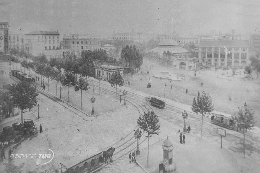 Otra imagen del siglo XIX.  Tranvías circulando por la plaza de Catalunya a finales de la década de 1880. En primer término, un tranvía jardinera de tracción animal. Las jardineras eran tranvías con los laterales abiertos que empezaron a circular a partir de 1873 durante los meses más cálidos, así el viaje era más agradable, y de paso se aligeraba el peso del vehículo del que tenían que tirar los animales.